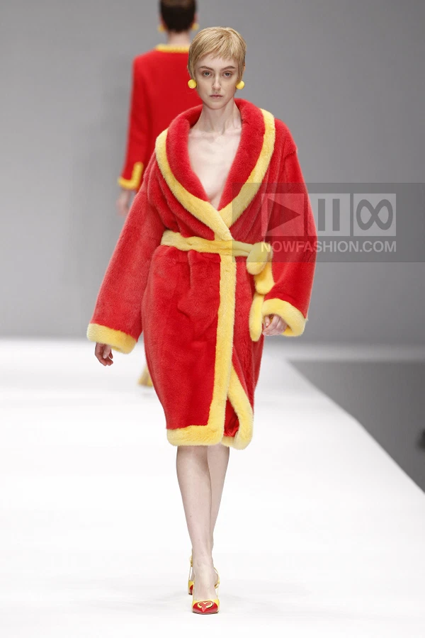 A model walks the runway in a bright red and yellow faux fur robe with a tie waist and matching yellow pumps.