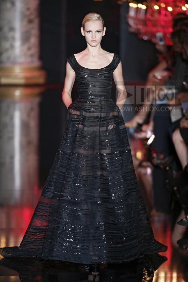 A black floor-length gown with horizontal sequined stripes and side-seam pockets on a runway.