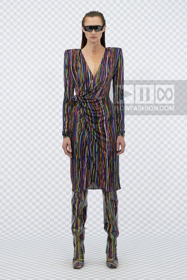 Model wearing a wrap dress with vertical rainbow stripes and matching over-the-knee boots against a checkered background.
